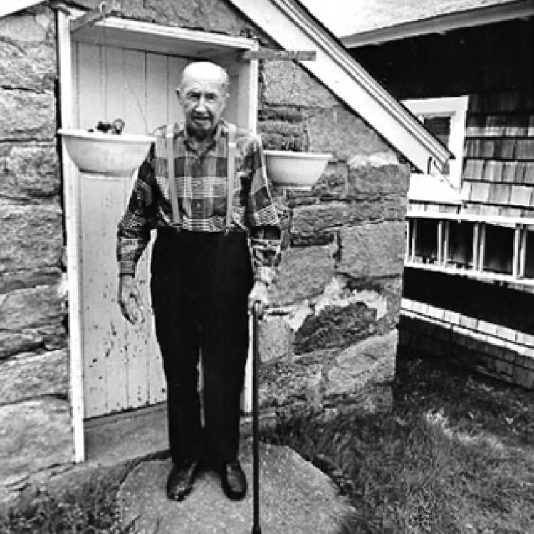 Russell Moxley, town policeman, outside his springhouse, Ellicott City